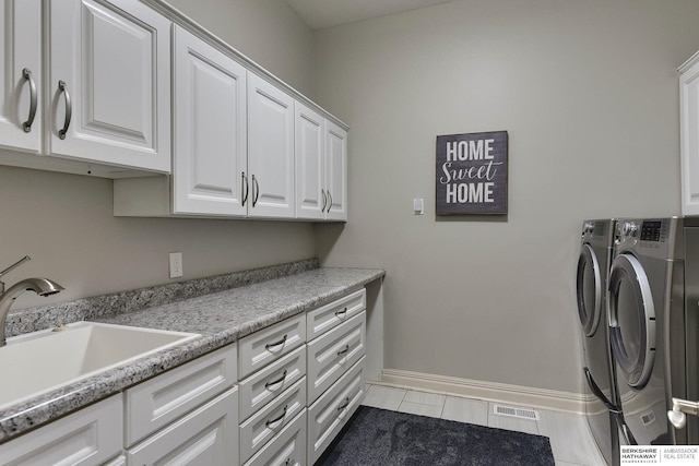 washroom featuring cabinets, sink, and independent washer and dryer