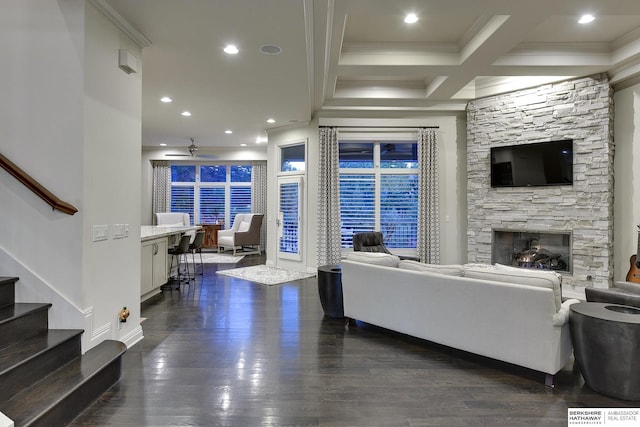 living room featuring coffered ceiling, a stone fireplace, crown molding, dark hardwood / wood-style flooring, and beamed ceiling