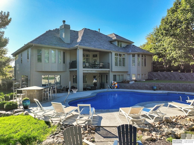 back of house with a fenced in pool and a patio area