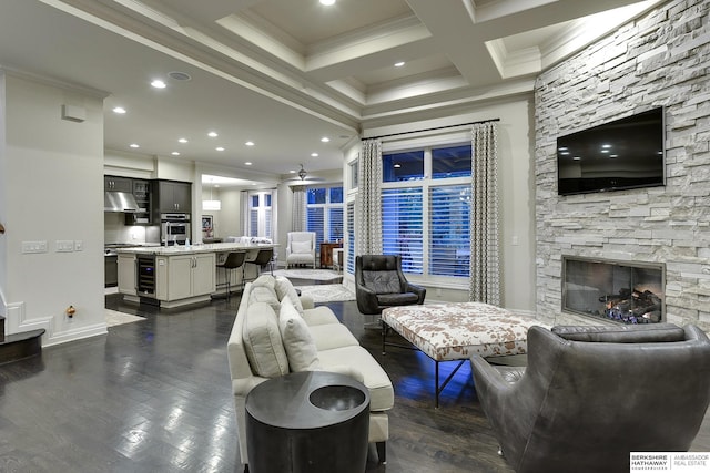 living room with beam ceiling, crown molding, dark hardwood / wood-style floors, and a fireplace