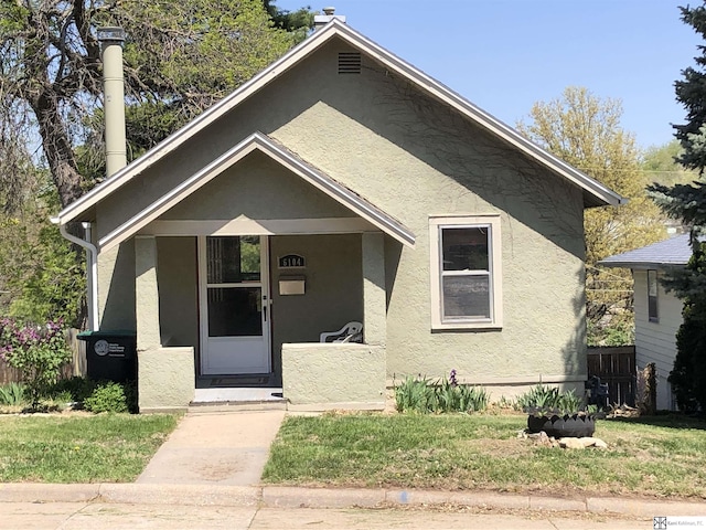 bungalow-style house with a front lawn