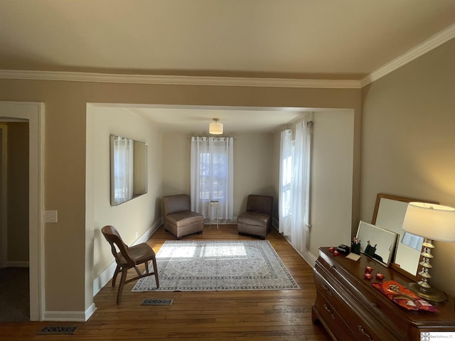 living area featuring ornamental molding and wood-type flooring