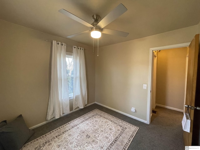unfurnished bedroom featuring ceiling fan and dark colored carpet