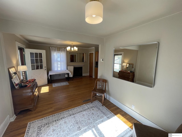 bedroom featuring crown molding, a notable chandelier, and dark hardwood / wood-style flooring