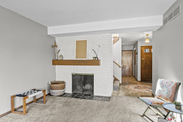 living room with a brick fireplace, dark carpet, and a textured ceiling