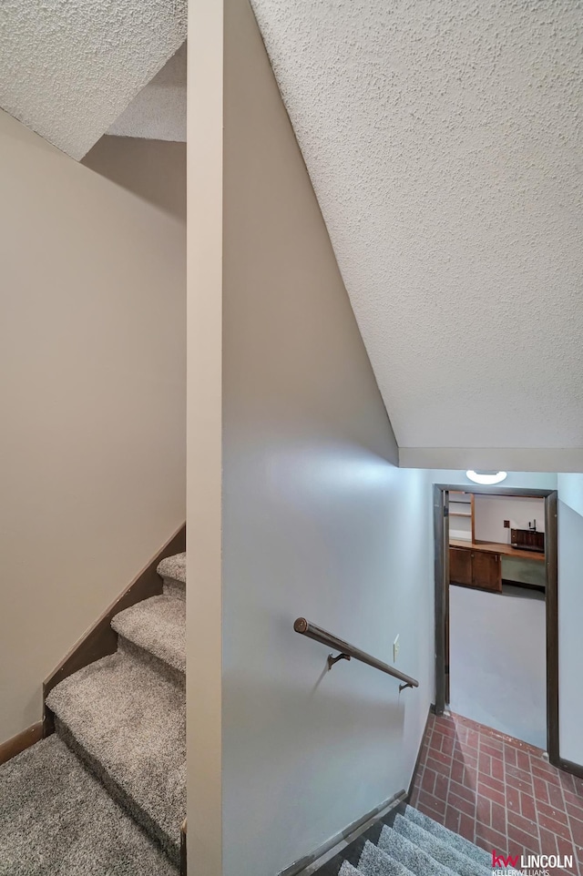 stairs with a textured ceiling