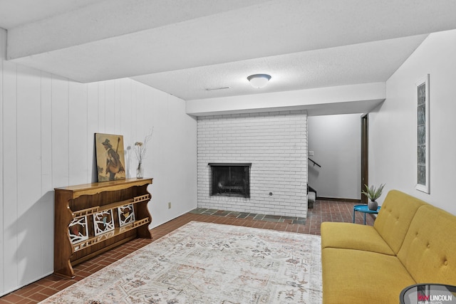 living room featuring a brick fireplace and a textured ceiling