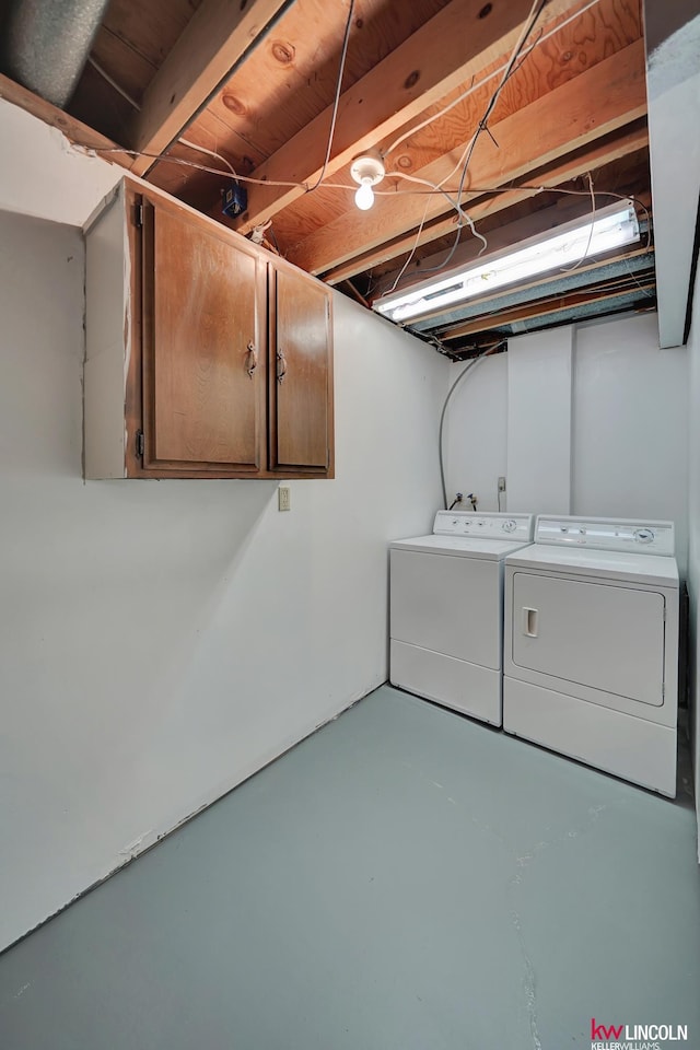 washroom with cabinets and washing machine and dryer