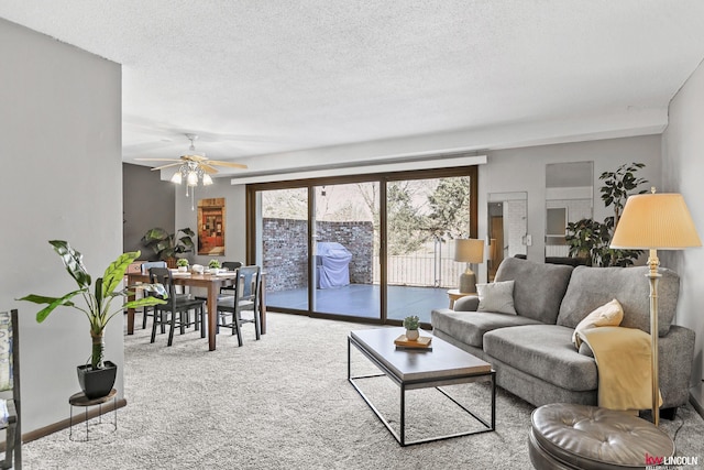 living room featuring ceiling fan, carpet, and a textured ceiling