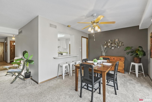 carpeted dining room featuring ceiling fan