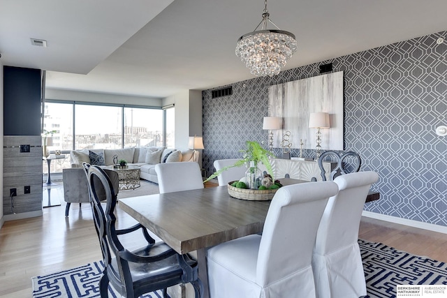 dining area featuring an inviting chandelier and light hardwood / wood-style floors