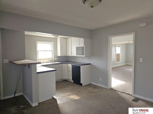 kitchen featuring sink, black dishwasher, dark colored carpet, white cabinets, and kitchen peninsula