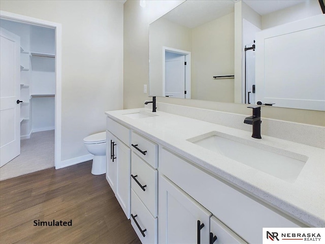 bathroom with wood-type flooring, toilet, and vanity