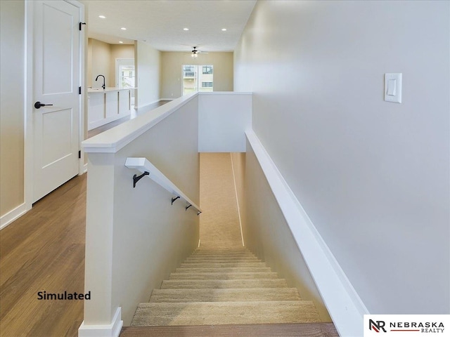 staircase with hardwood / wood-style floors and sink