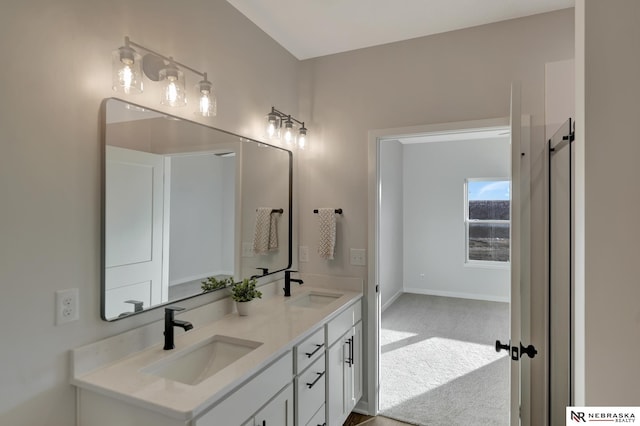 full bathroom with double vanity, baseboards, and a sink