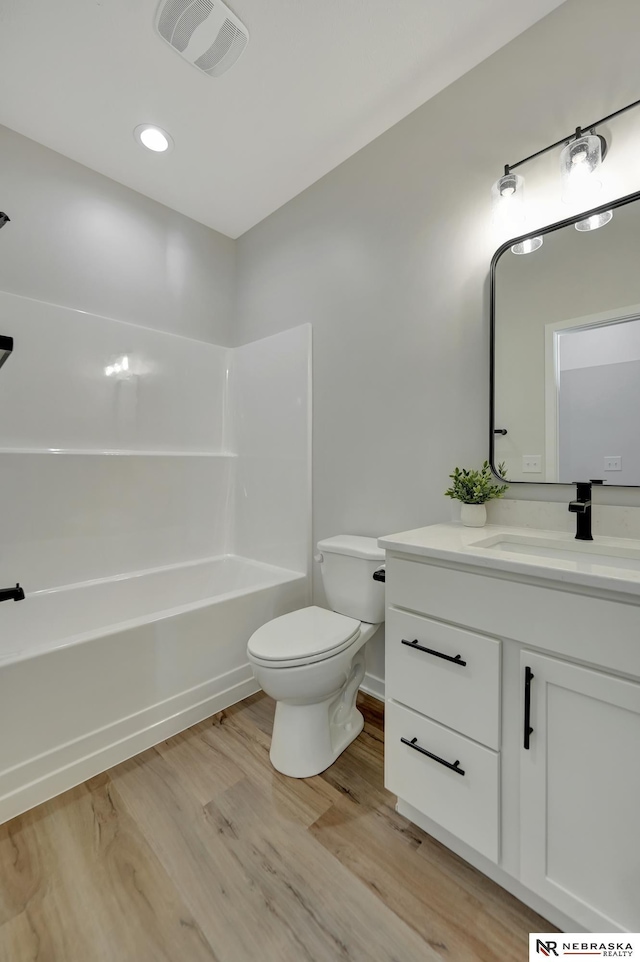 full bathroom featuring toilet, wood finished floors, visible vents, vanity, and  shower combination