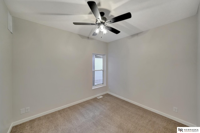 carpeted empty room featuring baseboards and a ceiling fan