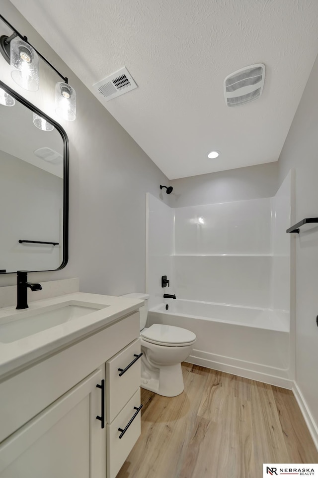 bathroom featuring toilet, shower / bathtub combination, wood finished floors, and visible vents