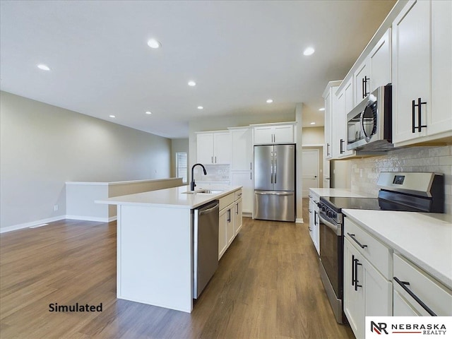 kitchen with wood finished floors, light countertops, appliances with stainless steel finishes, and a sink