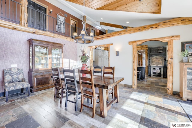 dining area with high vaulted ceiling and a chandelier