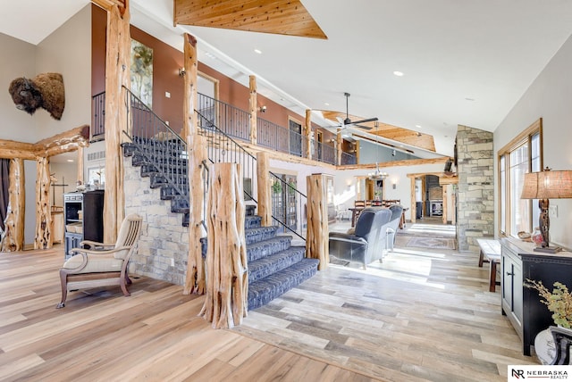 stairway featuring a towering ceiling, hardwood / wood-style floors, and ceiling fan