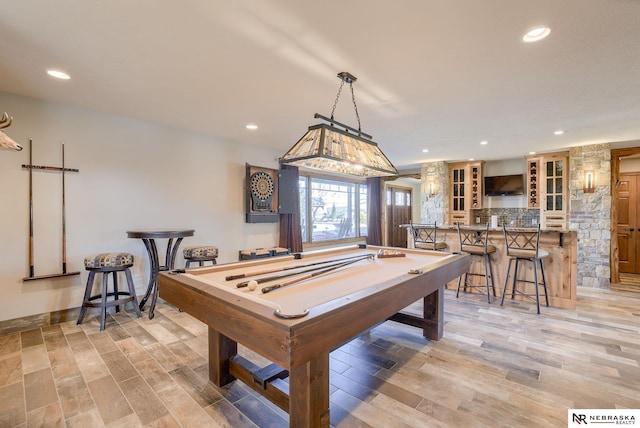 playroom featuring indoor bar, pool table, and light hardwood / wood-style flooring