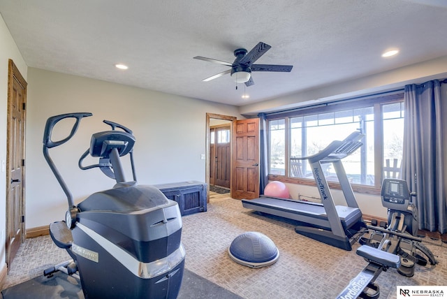 exercise area with ceiling fan, carpet floors, and a textured ceiling