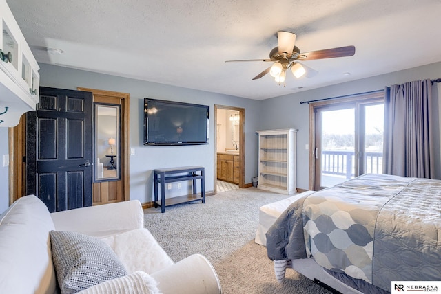 bedroom with ensuite bath, a textured ceiling, light carpet, and access to outside