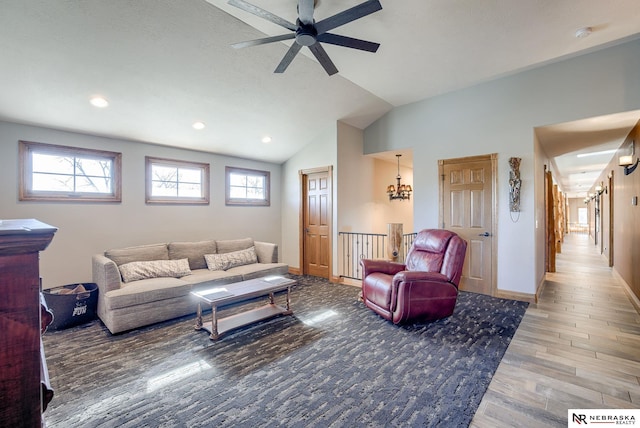 living room featuring wood-type flooring, vaulted ceiling, and ceiling fan with notable chandelier