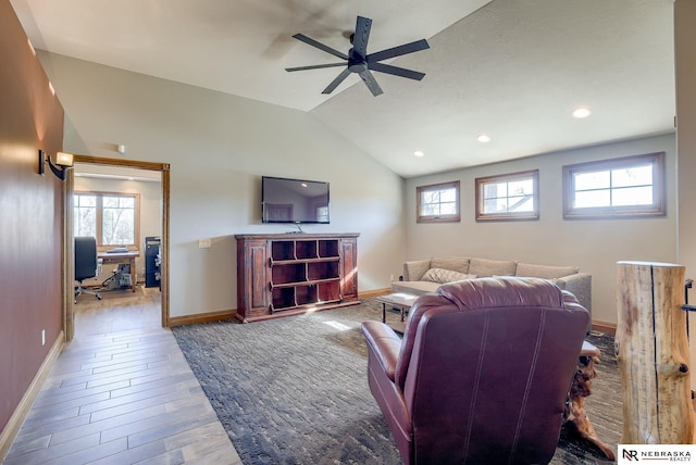 living room featuring hardwood / wood-style flooring, ceiling fan, and vaulted ceiling