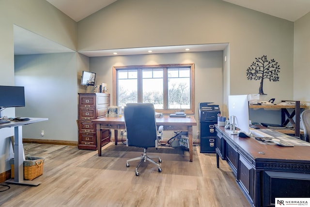 home office with vaulted ceiling and light hardwood / wood-style flooring