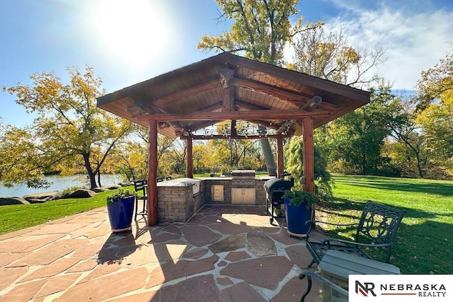 view of patio with a grill, a water view, area for grilling, and a gazebo