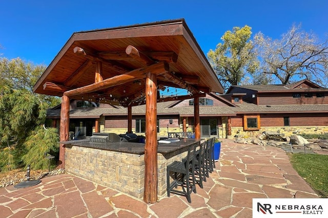 view of patio featuring exterior kitchen, grilling area, and a bar