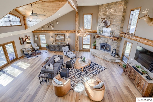 living room with plenty of natural light, a stone fireplace, and light wood-type flooring