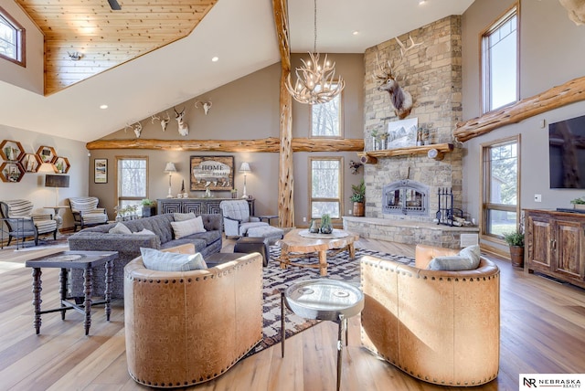 living room featuring an inviting chandelier, a fireplace, high vaulted ceiling, and light wood-type flooring