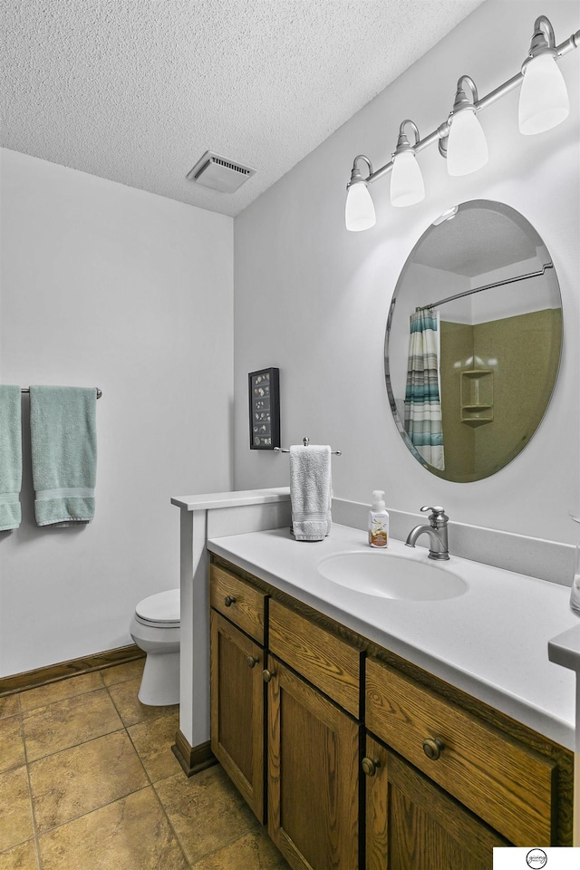 bathroom featuring a shower with curtain, vanity, toilet, and a textured ceiling