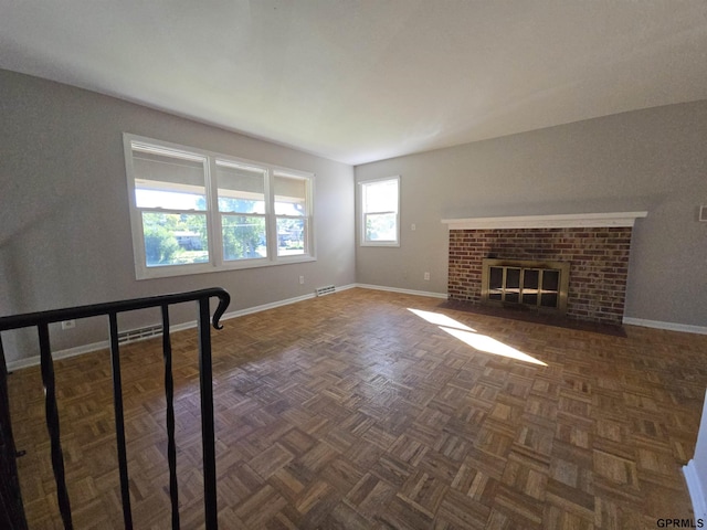 unfurnished living room with a fireplace and dark parquet floors