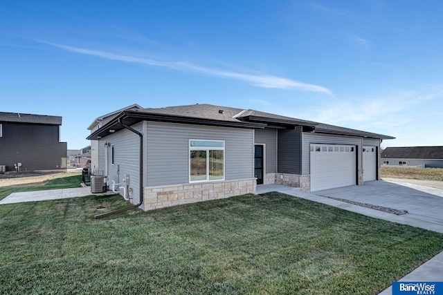 view of front of house with a garage, central AC, and a front yard