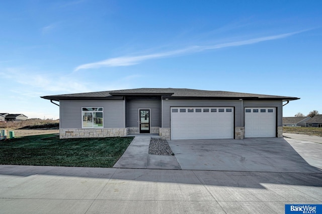 prairie-style home with a garage and a front lawn