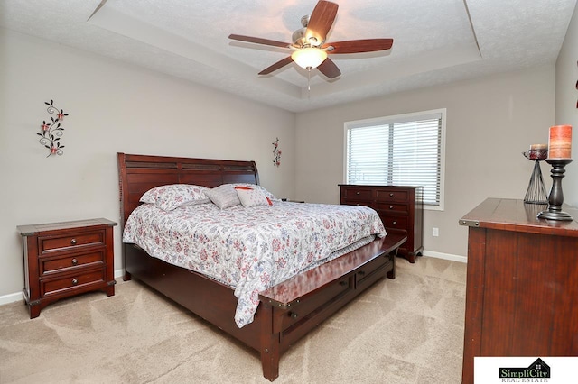 carpeted bedroom with ceiling fan, a raised ceiling, and a textured ceiling