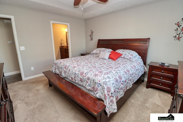 carpeted bedroom with a raised ceiling and ceiling fan