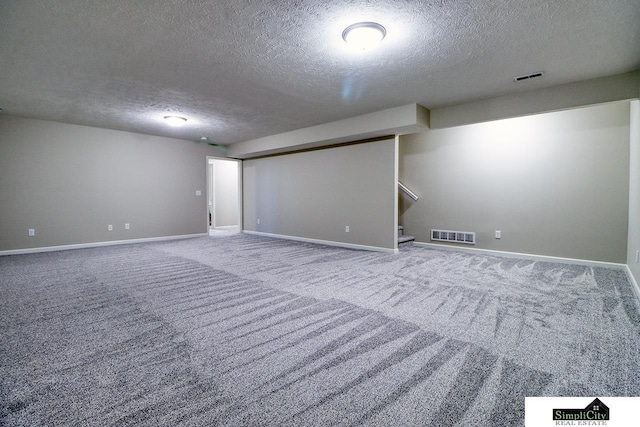 carpeted empty room with a textured ceiling