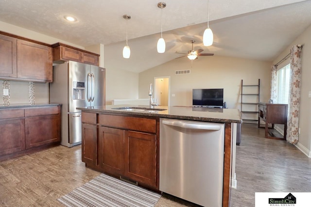 kitchen featuring pendant lighting, sink, light wood-type flooring, and appliances with stainless steel finishes