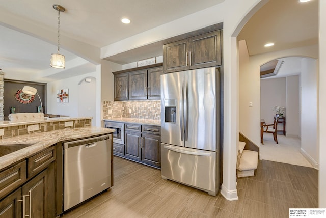 kitchen featuring decorative backsplash, dark brown cabinets, pendant lighting, and stainless steel appliances