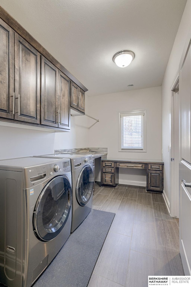 washroom featuring baseboards, cabinet space, and independent washer and dryer