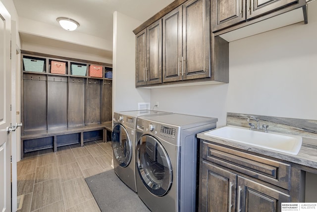 laundry room with cabinet space, independent washer and dryer, and a sink