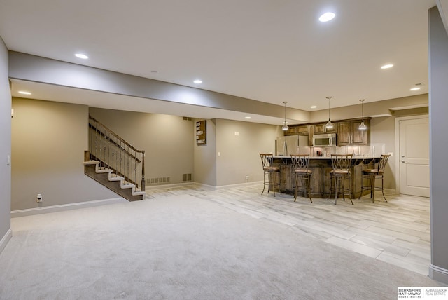 interior space with recessed lighting, a kitchen breakfast bar, appliances with stainless steel finishes, and open floor plan