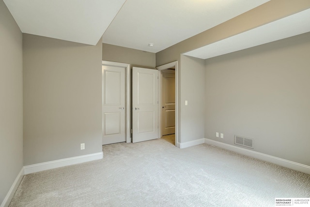 unfurnished bedroom featuring visible vents, baseboards, and light carpet