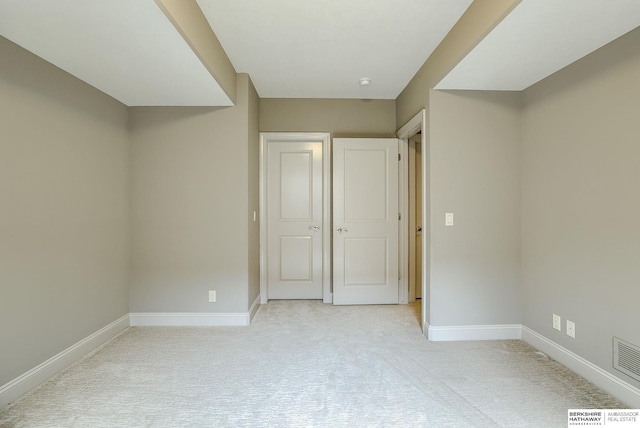 unfurnished bedroom featuring visible vents, baseboards, and light colored carpet