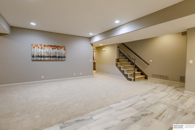 finished below grade area featuring stairs, recessed lighting, visible vents, and carpet floors